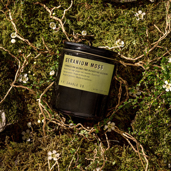 P.F. Candle Co. Wholesale Geranium Moss Alchemy Candle - Lifestyle - A connection blend to soak up the present moment, with notes of soft sage, ginger root, lavender, and patchouli. Inspired by overgrown wildflowers rooted in fresh earth, formulated with upcycled cedarwood and sustainable patchouli.