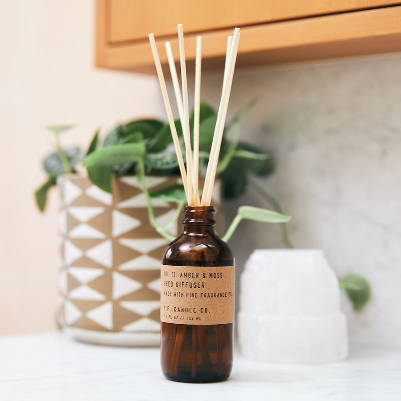 P.F. Candle Co. Wholesale Amber & Moss Reed Diffuser - Lifestyle - Scent notes of sage, moss, and lavender. Inspired by a weekend in the mountains, sun gleaming through the canopy.