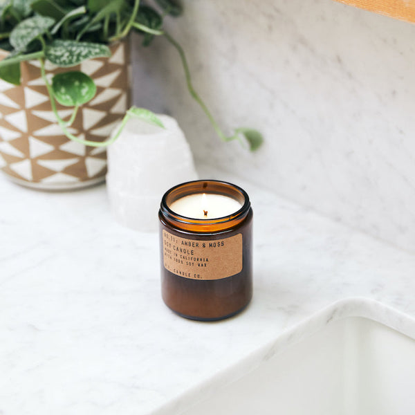 P.F. Candle Co. Wholesale Amber & Moss Standard Candle - Lifestyle - Scent notes of sage, moss, and lavender. Inspired by a weekend in the mountains, sun gleaming through the canopy.