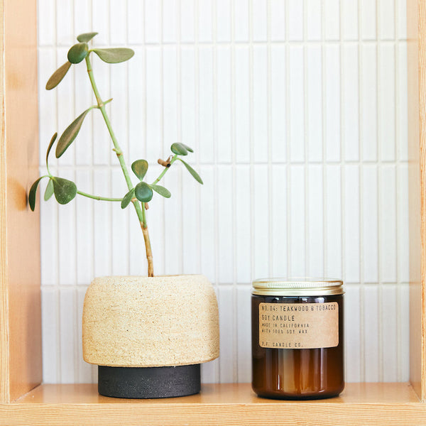 P.F. Candle Co. Wholesale Teakwood & Tobacco Standard Candle - Lifestyle - The one that started it all. Some call it the boyfriend scent, we call it the O.G. Leather, teak, and orange.