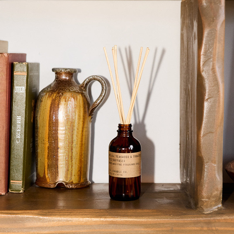 P.F. Candle Co. Wholesale Teakwood & Tobacco Reed Diffuser - Lifestyle - The one that started it all. Some call it the boyfriend scent, we call it the O.G. Leather, teak, and orange.